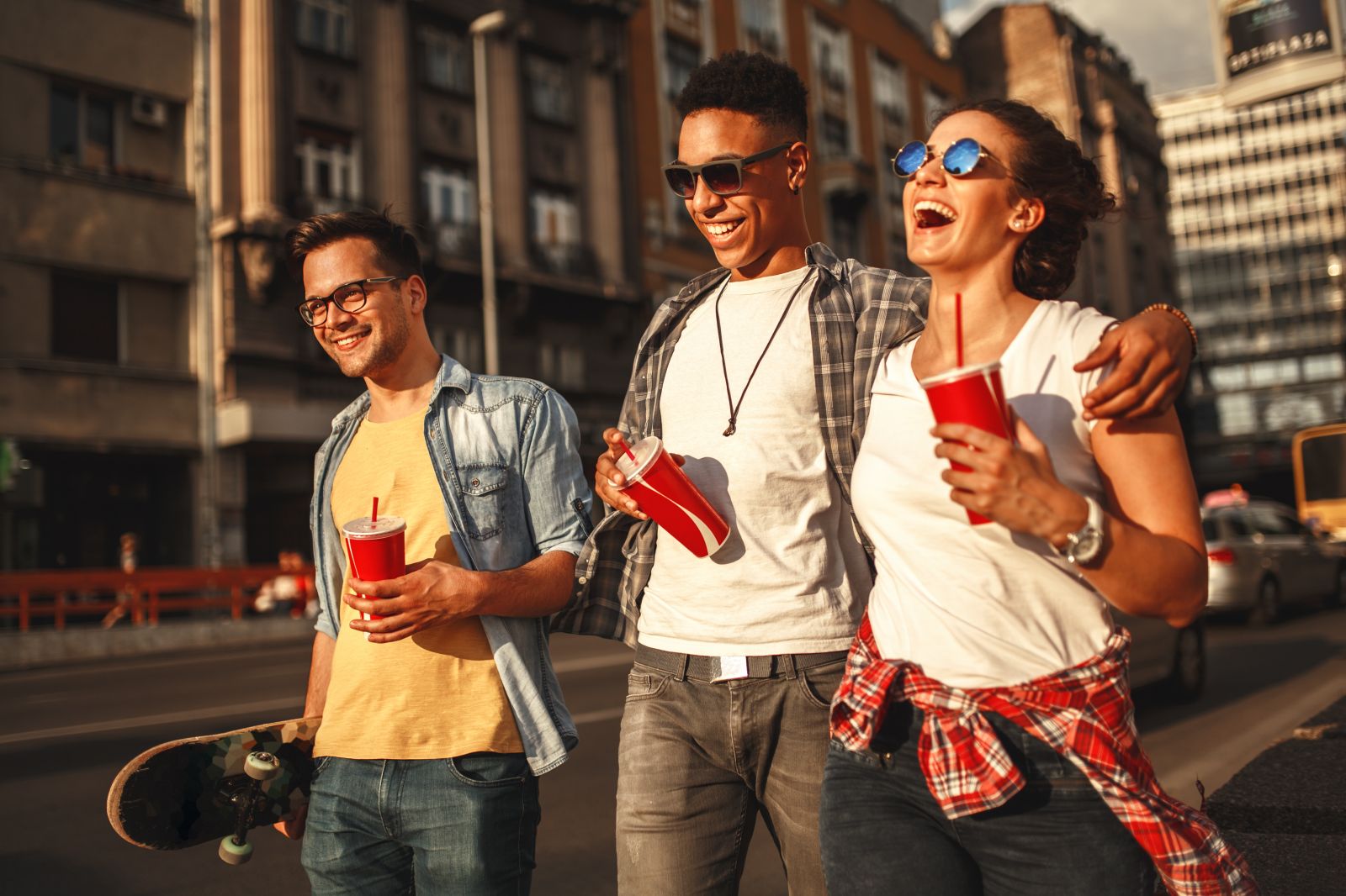 three students walking with drinks